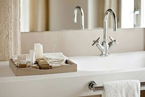 Bathroom with wooden tray holding toiletries