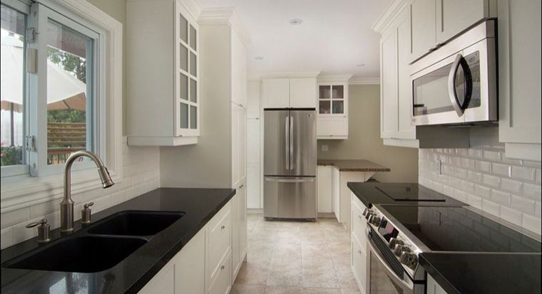 kitchen with white subway tile backsplash with solid black quartz countertops